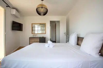 a large white bed with two stuffed animals on it at Apartment T2 air-conditioned sea view in Saint-Laurent-du-Var