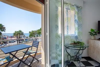 a balcony with a table and a view of the ocean at Apartment T2 air-conditioned sea view in Saint-Laurent-du-Var