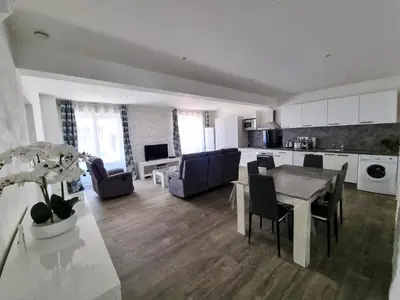 a kitchen and living room with a table and chairs at Bel appartement 2 chambres climatisé centre ville in Nice