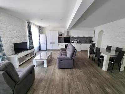 a living room with couches and a table and a kitchen at Bel appartement 2 chambres climatisé centre ville in Nice