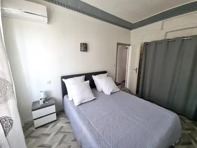 a bedroom with a bed with white sheets and pillows at Bel appartement 2 chambres climatisé centre ville in Nice