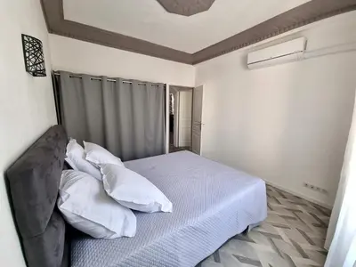 a bedroom with a bed with white sheets and pillows at Bel appartement 2 chambres climatisé centre ville in Nice