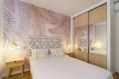 a bedroom with a white bed and a wall mural at Magnifique pavillon indépendant T2 Nice in Nice