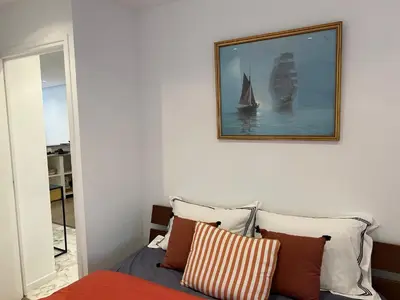 a bedroom with a bed and a picture of a sailboat at Nice la Belle, city centre 1 bed, 2 terrace, quiet in Nice