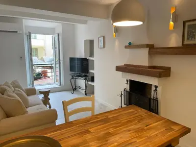 a living room with a table and a fireplace at Summerhouse 2 bed quiet Old Nice balcony100m beach in Nice