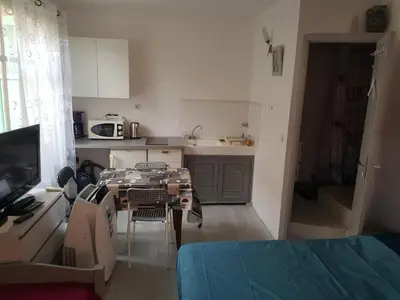 a small kitchen with a table and a room with a kitchen at studio pour 3 personnes au calme dans villa in Nice
