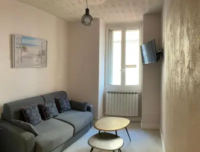 a living room with a couch and a table at appartement cosy - 2 chambres, situé en Centre Ville in Nice
