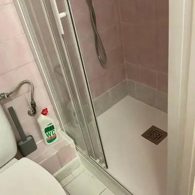 a shower with a glass door next to a toilet at appartement cosy - 2 chambres, situé en Centre Ville in Nice