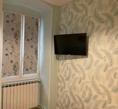 a flat screen tv on a wall next to a window at appartement cosy - 2 chambres, situé en Centre Ville in Nice