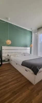 a bedroom with a white bed with a blue wall at cagnes promenade in Cagnes-sur-Mer