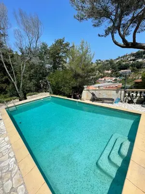 a large swimming pool with blue water at appartement bas de villa avec piscine privée partagée proche bord de mer in Cagnes-sur-Mer