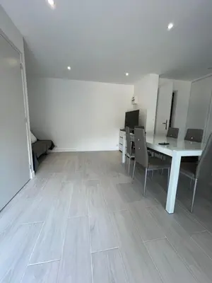 an empty room with a white table and chairs at appartement bas de villa avec piscine privée partagée proche bord de mer in Cagnes-sur-Mer