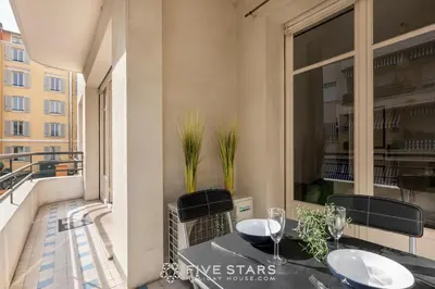 a balcony with a table and chairs and a window at Suite Reine Marie FSHH in Nice