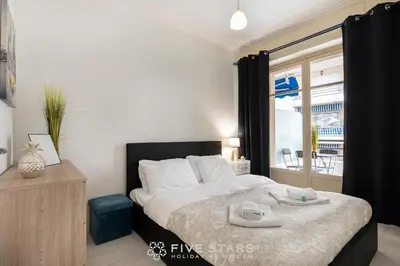 a bedroom with a large bed and a window at Suite Reine Marie FSHH in Nice
