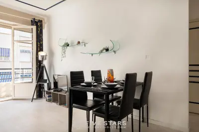 a dining room with a black table and black chairs at Suite Reine Marie FSHH in Nice