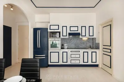 a kitchen with white cabinets and a blue refrigerator at Suite Reine Marie FSHH in Nice