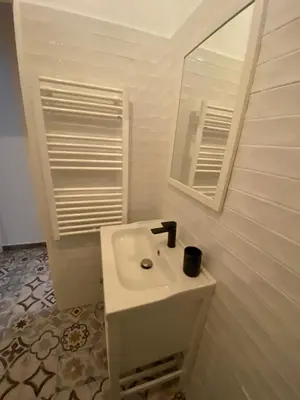 a white bathroom with a sink and a mirror at Vieille ville in Nice