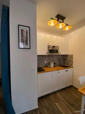 a kitchen with white cabinets and a microwave at Vieille ville in Nice