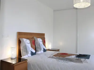 a bedroom with a bed with white sheets and pillows at Appartement Neuf 3 Pièces avec Terrasse et Garage, Cagnes-sur-Mer - FR-1-252A-88 in Cagnes-sur-Mer