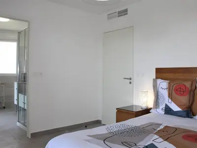 a bedroom with a bed and a glass door at Appartement Neuf 3 Pièces avec Terrasse et Garage, Cagnes-sur-Mer - FR-1-252A-88 in Cagnes-sur-Mer
