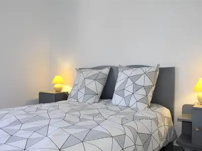 a bedroom with a white bed with two lamps at Appartement Neuf 3 Pièces avec Terrasse et Garage, Cagnes-sur-Mer - FR-1-252A-88 in Cagnes-sur-Mer
