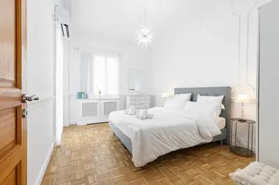a white bedroom with a large bed with white pillows at PROMENADE SEA VIEW - Terrasse vue mer in Nice