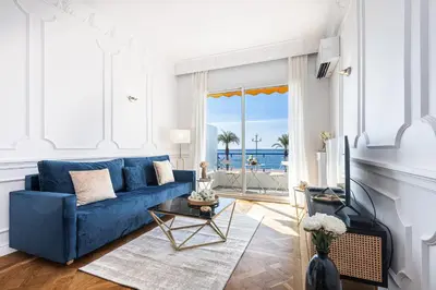 a blue couch in a living room with a view of the ocean at PROMENADE SEA VIEW - Terrasse vue mer in Nice