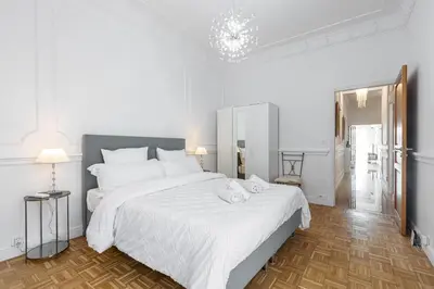 a white bedroom with a large bed with white sheets at PROMENADE SEA VIEW - Terrasse vue mer in Nice