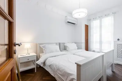 a white bedroom with a white bed and a window at PROMENADE SEA VIEW - Terrasse vue mer in Nice