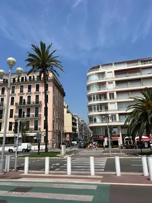 a city street with palm trees and a building at NICE - Central 100m plage- Negresco - IDEAL COUPLE in Nice