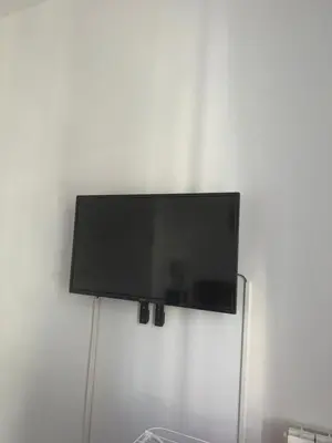 a flat screen tv hanging on a wall at NICE - Central 100m plage- Negresco - IDEAL COUPLE in Nice