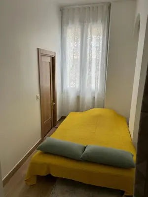 a bedroom with a yellow bed with a window at Villa Niçoise.3P. 5 min de la plage in Nice
