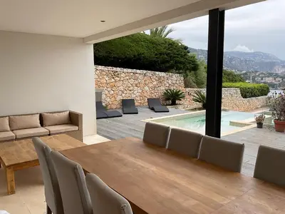 a dining room with a table and chairs and a pool at Villa LA ALEGRIA in Nice