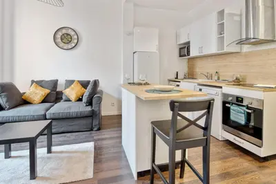 a kitchen and living room with a couch and a table at Appartement Oscarmony - Welkeys in Nice
