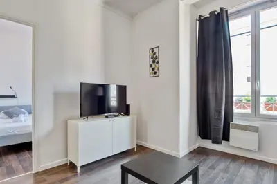 a living room with a tv on a white wall at Appartement Oscarmony - Welkeys in Nice