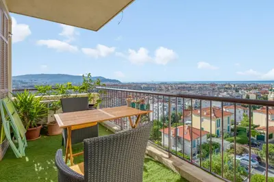 a balcony with a table and chairs and a view at Appartement Ayres - Welkeys in Nice