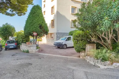 a building with cars parked in a parking lot at Appartement Ayres - Welkeys in Nice