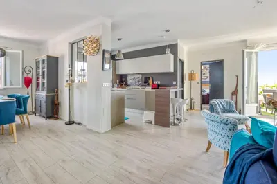 a kitchen and living room with blue and white furniture at Appartement Ayres - Welkeys in Nice