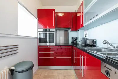 a red kitchen with red cabinets and a sink at Amazing Sea View 2Bdr Swimming Pool Parking in Villefranche-sur-Mer