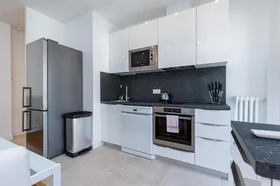 a kitchen with white cabinets and a stainless steel refrigerator at Quiet 1 Bdr Downtown Terrace AC & Parking in Nice