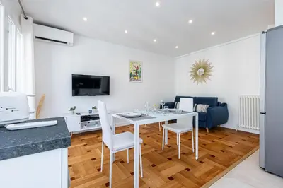 a kitchen and living room with a white table and chairs at Quiet 1 Bdr Downtown Terrace AC & Parking in Nice