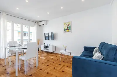 a living room with a blue couch and a table at Quiet 1 Bdr Downtown Terrace AC & Parking in Nice