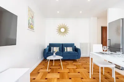a living room with a blue couch and a table at Quiet 1 Bdr Downtown Terrace AC & Parking in Nice