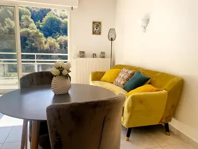 a living room with a table and a yellow couch at Villa Madeleine - Résidence Services Seniors in Nice
