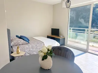 a bedroom with a table with a vase of flowers on it at Villa Madeleine - Résidence Services Seniors in Nice