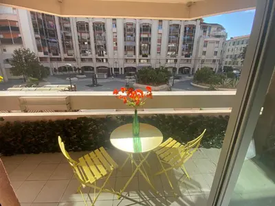 a table and chairs with a vase of flowers on it at Appartement 6 pers Port de Nice, mer et Vieux-Nice à pied in Nice