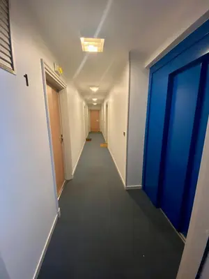 a long hallway with a blue door in an office building at Appartement 6 pers Port de Nice, mer et Vieux-Nice à pied in Nice