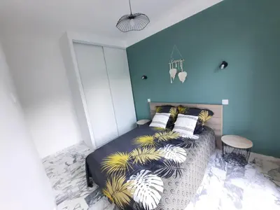 a bedroom with a bed with a blue wall at La Villa Castel - Haut de villa - parkings- 3 chambres - 8 couchages - jardin - barbecue in Cagnes-sur-Mer