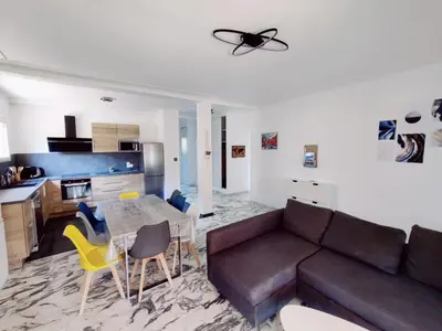 a living room with a couch and a table at La Villa Castel - Haut de villa - parkings- 3 chambres - 8 couchages - jardin - barbecue in Cagnes-sur-Mer