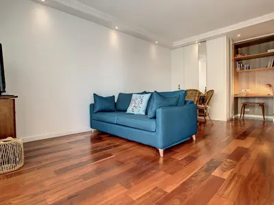 a blue couch in a living room with a wooden floor at BLUE RIVIERA TERRACE CENTRAL TRAIN STATION in Nice